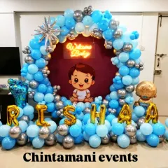 I created this adorable 'Welcome Baby' setup for a newborn boy's homecoming. The decor features a blue and silver balloon ring, a cute baby graphic, a neon sign, and the baby's name in large foil letters, making for a heartwarming welcome.
