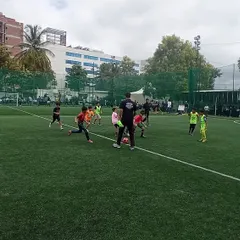 Our coach guiding a group of young players during a football drill. We focus on fun, fundamentals, and active participation.