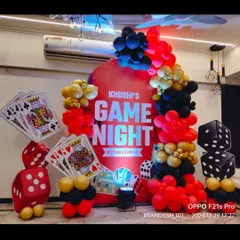 A unique 'Game Night' birthday theme. We used elements like giant playing cards, dice, and a red, black, and gold balloon garland to create a fun, casino-like atmosphere for Khushi's birthday.