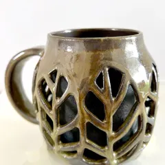 A close-up of a double-walled leaf mug I created. The intricate carving allows the inner wall to show through, creating a beautiful and delicate effect.
