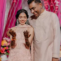 A sweet moment between the bride and her father as she shows off her intricate mehendi design. Our planning ensures you can cherish these quiet, personal moments amidst the celebration.