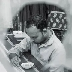 An artisan at his station, focused on the intricate process of hand embroidery. Each stitch is placed with precision and care.