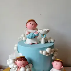 An angelic baptism cake in soft blue. This design features several cherubic angels sitting amongst fluffy fondant clouds, with one angel holding the baby. It’s a heavenly cake to celebrate a new beginning in faith.