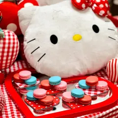A close-up of the Hello Kitty themed party, with colorful macarons displayed on a heart-shaped mirror tray next to an adorable Hello Kitty plushie.