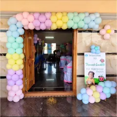 A sweet and simple entrance for Thaneesh's Cocomelon party, with a pastel balloon arch over the doorway and a personalized welcome sign.