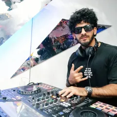 Posing with a rock-on sign from behind the decks. I bring confidence and a cool attitude to every performance.