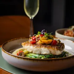 A hearty main for any day of the week. This beautifully pan-seared fish rests on a bed of greens and is topped with a fresh tomato salsa, paired perfectly with a glass of crisp bubbly.
