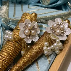This elegant trousseau packaging was designed for a Teej ceremony. The pearl and crystal flower embellishments on the golden cones add a touch of bridal charm and sophistication.