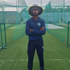 Our coach Chinna standing in front of our Astro Turf nets. We have 14 such wickets to ensure players can train on any surface and get ample practice time.