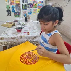 A quiet moment of concentration as a young participant paints a vibrant design on her yellow umbrella. My workshops are a space for both fun and focus.