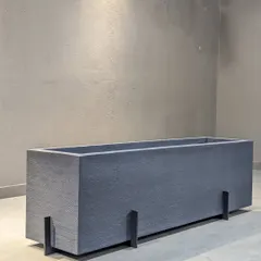 This sleek, rectangular planter in a dark grey finish is made from lightweight fiber. Its modern, minimalist design is perfect for creating clean lines in both outdoor and indoor settings.