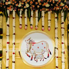 A close-up of the central motif in our cow-themed decoration. The illustration of the cow and calf is framed by hanging garlands of jasmine and lotus buds, adding to the serene and traditional feel.