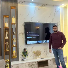 Here I am, standing next to a completed TV unit. This project showcases how we can create a beautiful and functional entertainment wall that becomes the highlight of the living space.