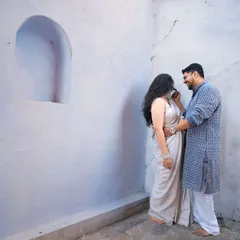 A quiet, intimate moment during a pre-wedding shoot. The simplicity of the white walls draws all the focus to the couple's connection.