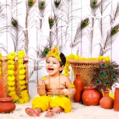 The playful spirit of childhood shines in our Little Krishna themed photoshoot. We create a vibrant and authentic setting with peacock feathers, marigold garlands, and traditional clay pots, capturing your child's joyful laughter and divine charm.