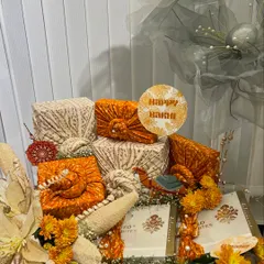 Another view of the traditional Rakhi setup, highlighting the fabric-wrapped gifts and floral arrangements.