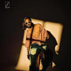 A powerful seated pose where the hard light creates a stark, graphic shape on the background, framing the model in a unique way.
