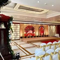 A unique and artistic stage for a 'Raas Leela' themed event, featuring large, graphic representations of traditional male and female faces against a textured backdrop.