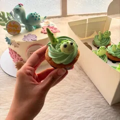 A sweet dinosaur-themed birthday cake for a little girl. I paired the main cake with matching dino cupcakes, all in a lovely pastel color palette.