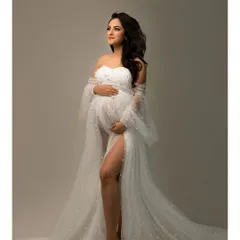 A solo portrait capturing the quiet strength and beauty of motherhood. The flowing white gown adds a touch of ethereal grace to this timeless image.
