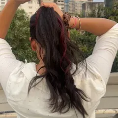 Ditch the dye. This client is enjoying a pop of red in her ponytail using our Colour Strands. It's a fun, easy way to play with color without the commitment or damage.