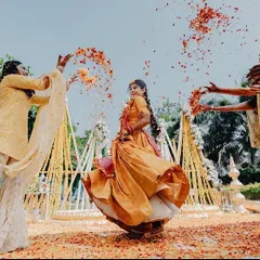 The pure joy of a Haldi ceremony! This candid shot captures the bride having fun with her friends, with flower petals being showered on her. Our decor provides the perfect, colorful backdrop for such happy moments.