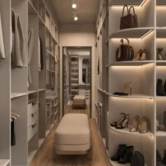 A long, galley-style walk-in closet with ample storage on both sides. This view highlights the curved shelving for shoes and bags, demonstrating a custom approach to organization.