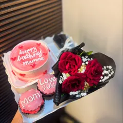 A lovely mini hamper featuring a pink bento cake for "Mummy's" birthday. It's paired with matching cupcakes and a beautiful bouquet of fresh red roses, creating a complete and thoughtful gift set.