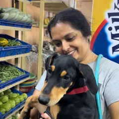 Socialization includes getting puppies comfortable with everyday activities. Here, little Doberman puppy Alpha joins his human for vegetable shopping. This exposes him to new people, sounds, and smells in a controlled way, building a foundation for a stress-free life.