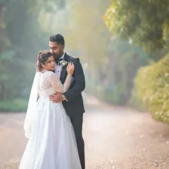 An intimate embrace in a beautiful, light-filled setting. This portrait feels both classic and candid, showcasing the couple's connection and the elegance of their wedding attire.