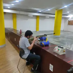 A student practices his aim during a training session. Regular practice is key to improving hand-eye coordination and consistency in shooting.