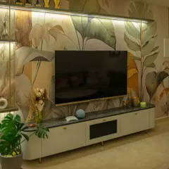 I believe walls are a canvas for art. Here, a custom botanical wallpaper from my collection serves as a stunning backdrop for a sleek, modern television unit, demonstrating how I integrate technology and nature-inspired design seamlessly.