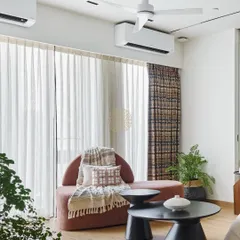 A cozy seating area in the girls' room with a curved pink chaise and modern black coffee tables. The space is designed to be comfortable for both kids and parents to relax in.