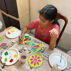 A young artist completely focused on her creation during our Diwali Lippan Art workshop. She is carefully painting a traditional design on a tea light holder, learning about patterns and colors while making a beautiful craft for the festival of lights.