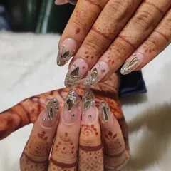 This angle shows the full effect of the crystal-encrusted bridal nails against the intricate mehendi design. Each gem is carefully secured for a look that's both stunning and durable for all your wedding functions.