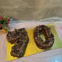 A number "70" monogram cake for a milestone birthday. This rich chocolate cake is loaded with various chocolates and candies.