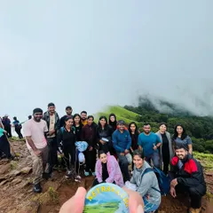 Our group at the top of Netravathi Peak, with our custom trek badge in the foreground. A perfect memory of a challenging and beautiful climb.