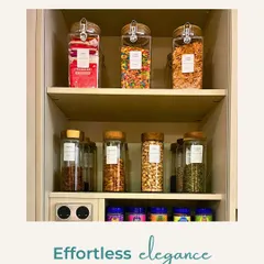 Effortless elegance in the pantry. Clear, labeled jars for snacks and cereals create a clean, uniform look on open shelves.