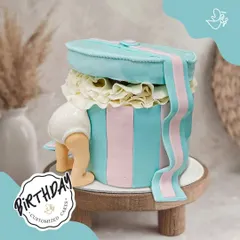 Peek-a-boo! This cute baby-themed cake was made for Sujay's birthday in Gurugram. The design of a baby peeking out of a gift box is an adorable and unique idea for a toddler's birthday.