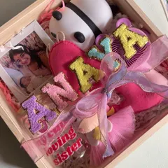 A close-up of the personalized Rakhi hamper for baby Anaya, showing the custom name banner, photo, and cute accessories.