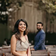 A beautiful candid portrait of the bride-to-be at her engagement party, with her fiancé looking on from the background.