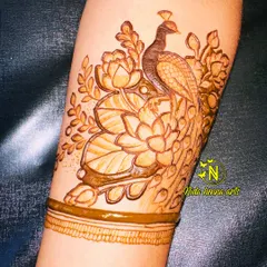 A beautiful bridal arm band design featuring a peacock surrounded by lotuses. These classic elements are essential for any bridal mehandi artist to master.