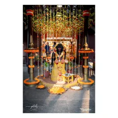 A sacred space set up for a naming ceremony ritual. The area is defined by a canopy of flowers and traditional brass lamps, creating a divine atmosphere.