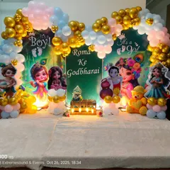 A vibrant Krishna-themed Godh Bharai decoration. This setup features cutouts of baby Krishna and Radha, a 'It's a Boy/It's a Girl' backdrop, and a colorful balloon arch in gold, pink, and blue.