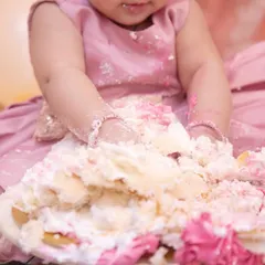 It's not a party until there's cake everywhere. This close-up shot captures the delightful mess of a first birthday cake smash.