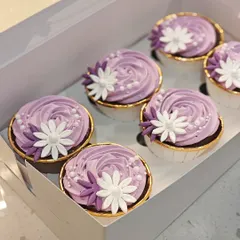 A box of the matching cupcakes that went with the vintage cake. These feature beautiful purple frosting with white and purple sugar flowers, tying the whole theme together.