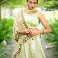 A beautiful pastel green lehenga with delicate embroidery, perfect for a daytime event. We styled this look with a statement matha patti and choker for a touch of modern elegance.