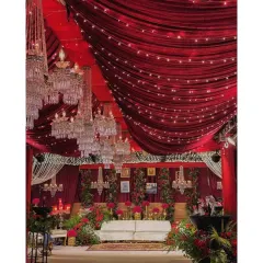 Go big or go home. For this reception, we used rich red velvet drapes across the entire ceiling, dozens of crystal chandeliers, and dramatic floral arrangements to create a warm and luxurious atmosphere. This is our signature red romantic theme.