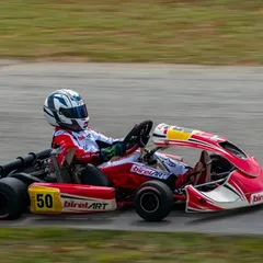 A Birel ART driver with number 50 navigates the track at speed, demonstrating the focus and control we instill in our racers during training and competition.