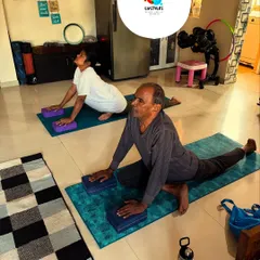 Two of my senior clients work on hip flexibility and strength using yoga blocks for support. My programs for seniors are designed to improve mobility and prevent falls.